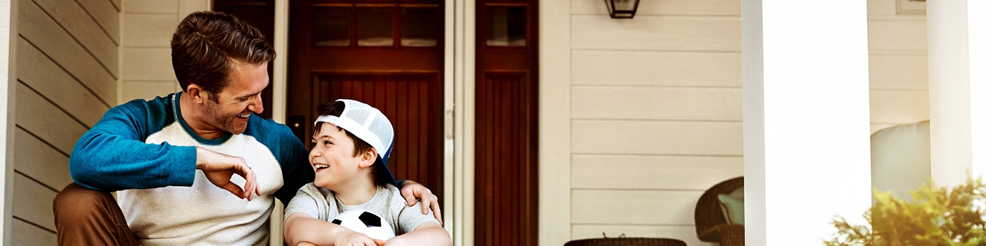 Father and his son laughing and talking on their porch at home