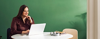 Businesswoman working on laptop at a table