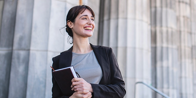 Businesswoman standing in front of government building columns 