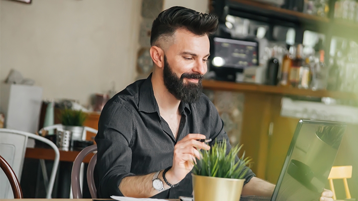 Businessman working in a cafe on his laptop.