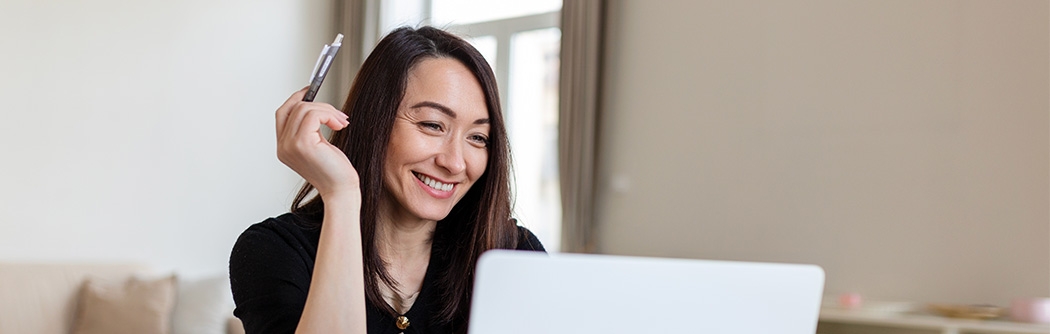 Smiling businesswoman working on laptop.