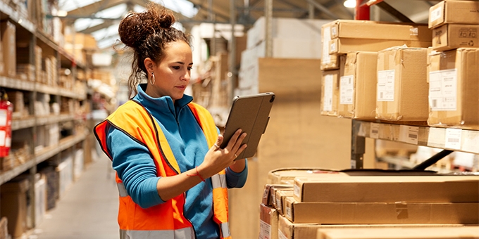 Woman using a tablet in a warehouse.