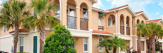 Senior housing building with tropical trees on a sunny day.