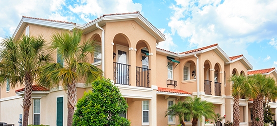 Senior housing building with tropical trees on a sunny day.