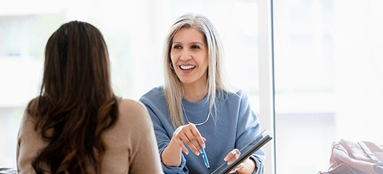 Businesswoman talking with client in office.