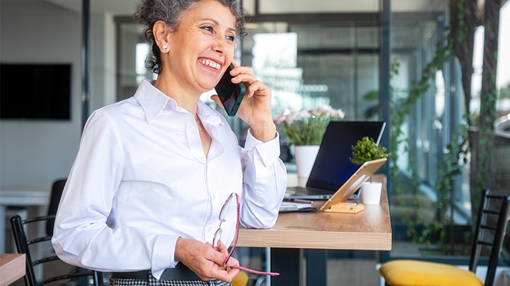 A mature businesswoman on a mobile phone in her office building.