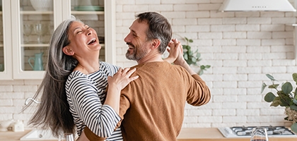 Feliz pareja bailando juntos en la cocina.