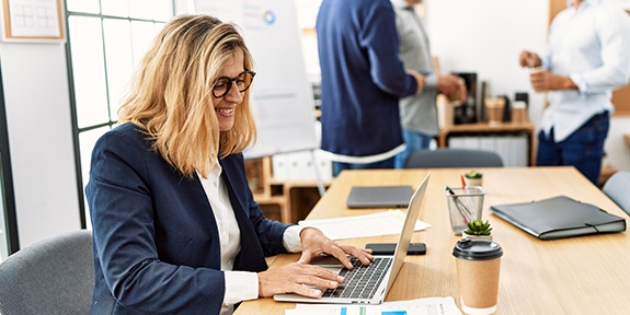 Woman working on laptop in an office.