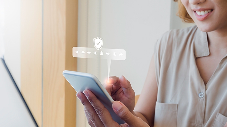 Woman entering secure password on smartphone, secure icon above