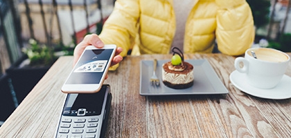 Woman paying for dessert with digital debit card mobile pay.