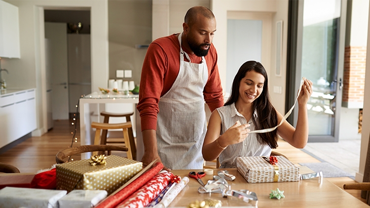 Happy couple wrapping holiday presents.