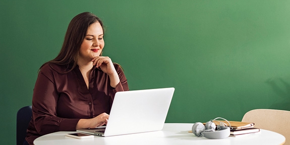 Businesswoman working on laptop at a table