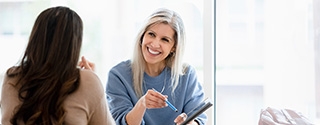 Two businesswomen reviewing a document on a tablet.