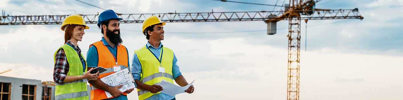 Engineer, architect, and contractor on the construction site with a crane in the background.