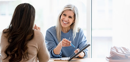 Two businesswomen reviewing a document on a tablet.