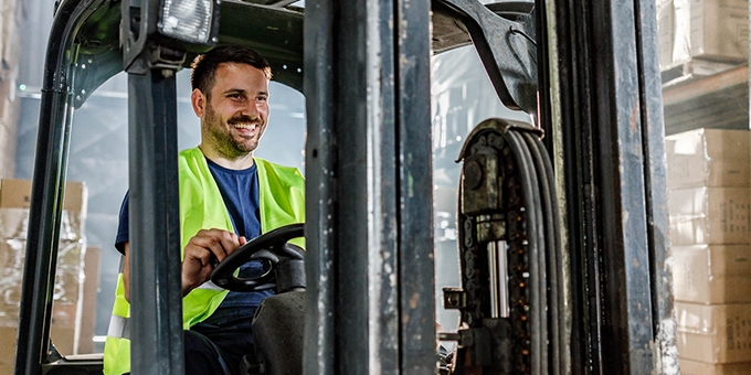 Warehouse worker driving a forklift in a storage room