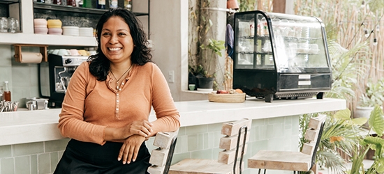 Business owner sitting at cafe bar stool.