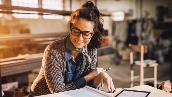 Businesswoman holding a pen and smiling.