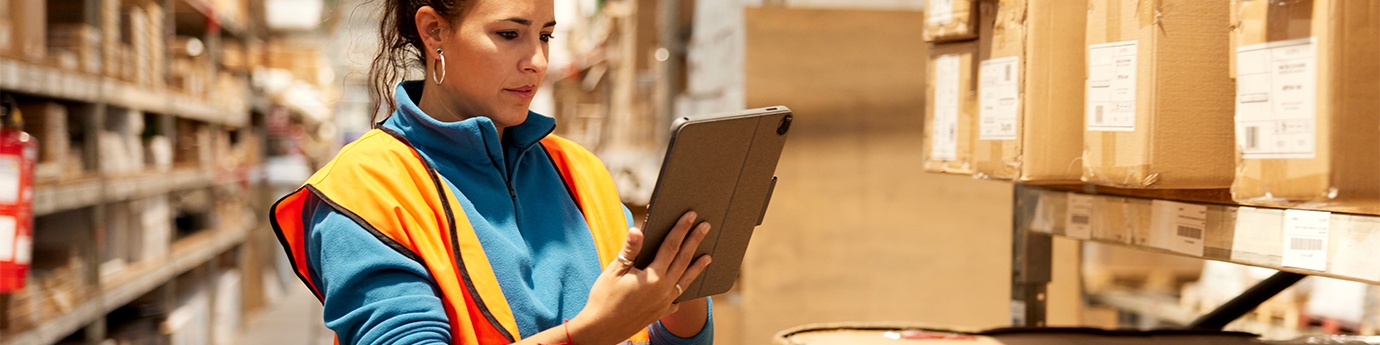 Woman using a tablet in a warehouse.