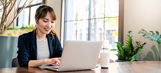 Businesswoman working on laptop at office desk.