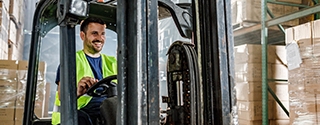 Warehouse worker driving a forklift in a storage room