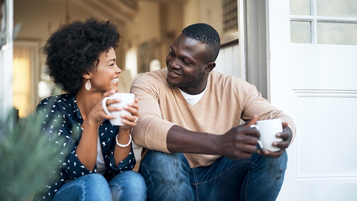 Happy young couple spending time together outside with coffee