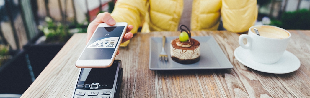 Woman paying for dessert with digital debit card mobile pay.